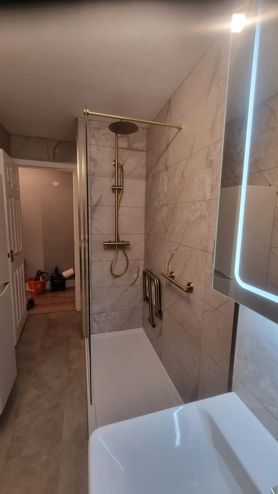 Brass shower fittings with marble-effect wall panels